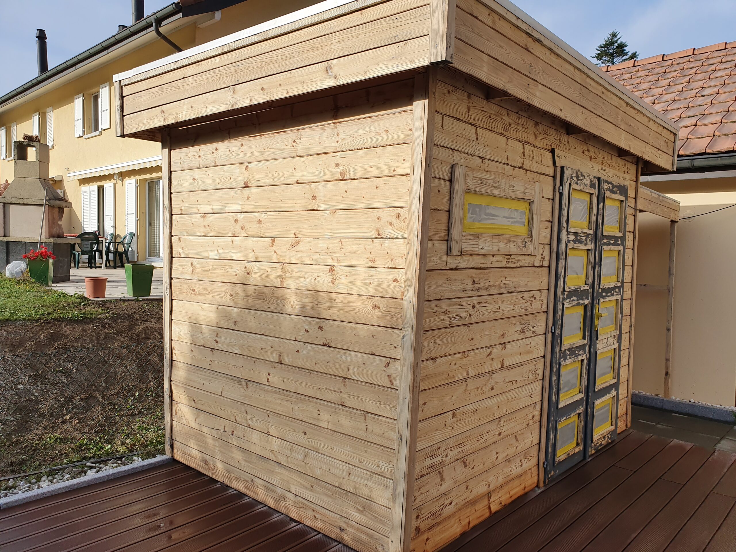Abri de jardin en bois clair neuf posé sur une terrasse